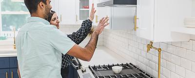 Couple inspecting a kitchen while touring a home.