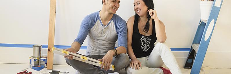 Couple sitting on the floor with renovation tools.