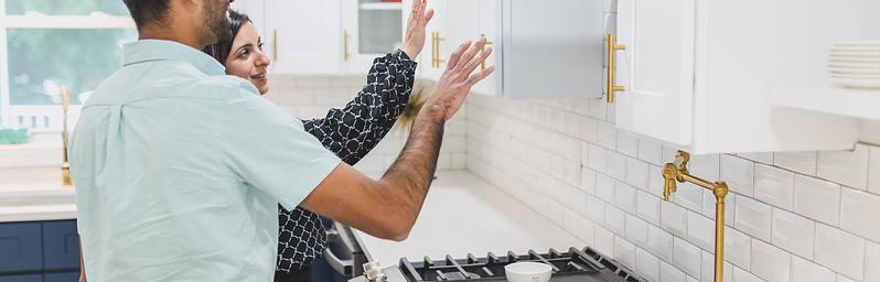 Couple inspecting a kitchen while touring a home.