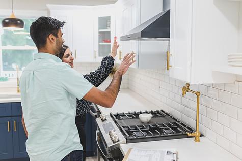 Couple inspecting a kitchen while touring a home.