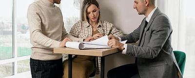 Couple reviewing documents with a real estate agent.