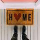 Welcome mat with a heart, symbolizing the benefits and emotional value of buying a home.