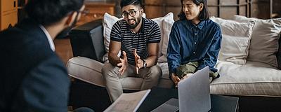 Couple discussing home selling strategies with a real estate agent.