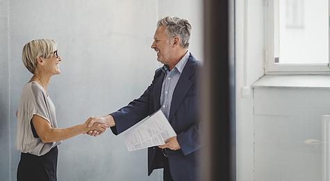 Real estate professional shaking hands with a client.