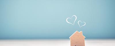 Small wooden house with heart shapes above it.