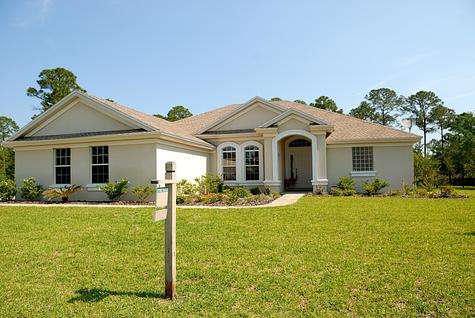 Single-story house with a for-sale sign in the yard.