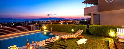 Luxurious vacation home with a pool and scenic view at sunset.