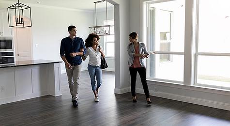 Couple touring a home with a real estate agent.