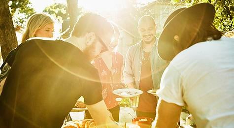 Group of friends enjoying a meal together in their backyard.