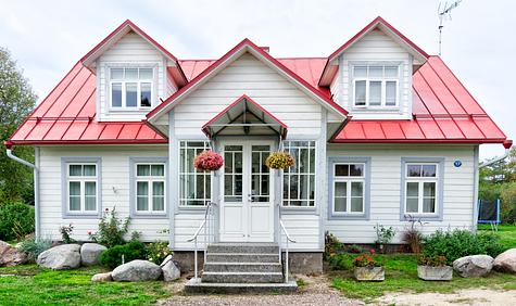 Front view of a white house with a red roof.
