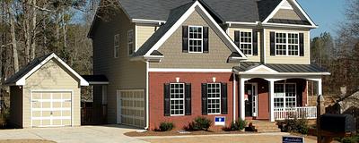 Two-story house with a for-sale sign.